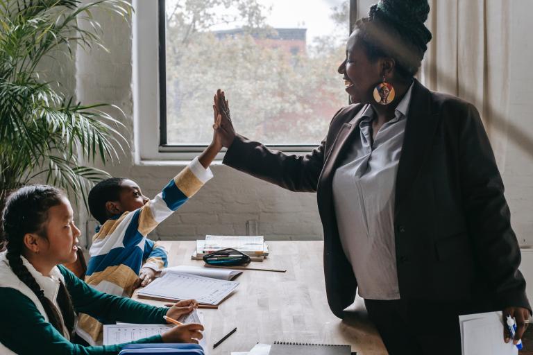 school teacher high-fiving student