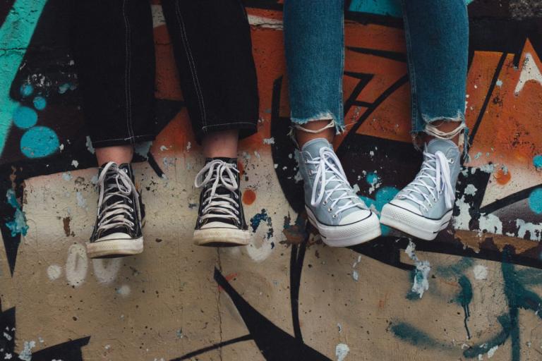 view of trainers of young people sitting on a wall