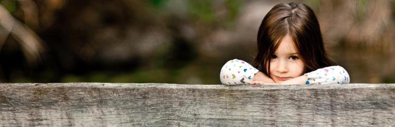 girl looking over a fence